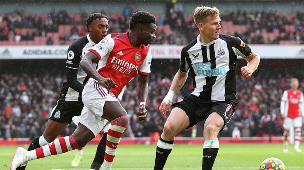 Arsenal's English midfielder Bukayo Saka (L) vies with Newcastle United's Scottish midfielder Matt Ritchie during the English Premier League football match between Arsenal and Newcastle United at the Emirates Stadium in London on November 27, 2021. (Photo by Adrian DENNIS / AFP) / RESTRICTED TO EDITORIAL USE. No use with unauthorized audio, video, data, fixture lists, club/league logos or 'live' services. Online in-match use limited to 120 images. An additional 40 images may be used in extra time. No video emulation. Social media in-match use limited to 120 images. An additional 40 images may be used in extra time. No use in betting publications, games or single club/league/player publications. / 