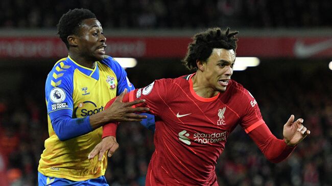 Southampton's English midfielder Nathan Tella (L) vies with Liverpool's English defender Trent Alexander-Arnold during the English Premier League football match between Liverpool and Southampton at Anfield in Liverpool, north west England on November 27, 2021. (Photo by Oli SCARFF / AFP) / RESTRICTED TO EDITORIAL USE. No use with unauthorized audio, video, data, fixture lists, club/league logos or 'live' services. Online in-match use limited to 120 images. An additional 40 images may be used in extra time. No video emulation. Social media in-match use limited to 120 images. An additional 40 images may be used in extra time. No use in betting publications, games or single club/league/player publications. / 