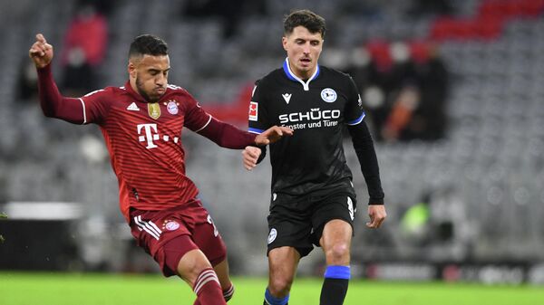 Bayern Munich's French midfielder Corentin Tolisso (L) and Bielefeld's Austrian midfielder Alessandro Schoepf (R) vie for the ball vie for the ball during the German first division Bundesliga football match FC Bayern Munich v Arminia Bielefeld in Munich, southern Germany, on November 27, 2021. (Photo by Christof STACHE / AFP) / DFL REGULATIONS PROHIBIT ANY USE OF PHOTOGRAPHS AS IMAGE SEQUENCES AND/OR QUASI-VIDEO