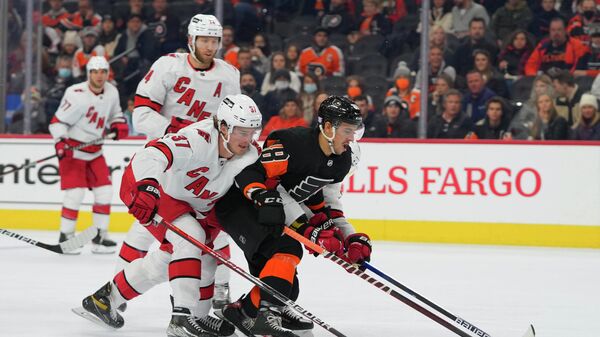 Nov 26, 2021; Philadelphia, Pennsylvania, USA; Philadelphia Flyers center Morgan Frost (48) battles for the puck with Carolina Hurricanes right wing Andrei Svechnikov (37) in the first period at the Wells Fargo Center. Mandatory Credit: Mitchell Leff-USA TODAY Sports