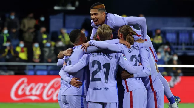Barcelona's players celebrate their third goal scored by Brazilian midfielder Philippe Coutinho during the Spanish league football match between Villarreal CF and FC Barcelona at La Ceramica stadium in Vila-real on November 27, 2021. (Photo by JOSE JORDAN / AFP)