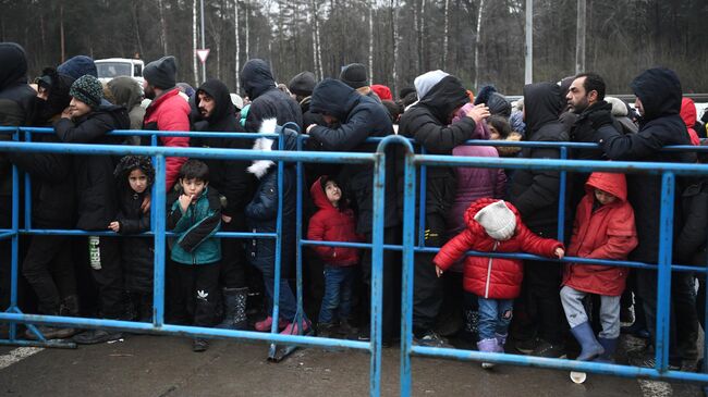 Беженцы в центре временного содержания мигрантов, оборудованном в логистическом центре в пункте пропуска Брузги