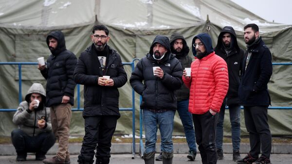 Беженцы в лагере мигрантов, оборудованном в логистическом центре в пункте пропуска Брузги на белорусско-польской границе