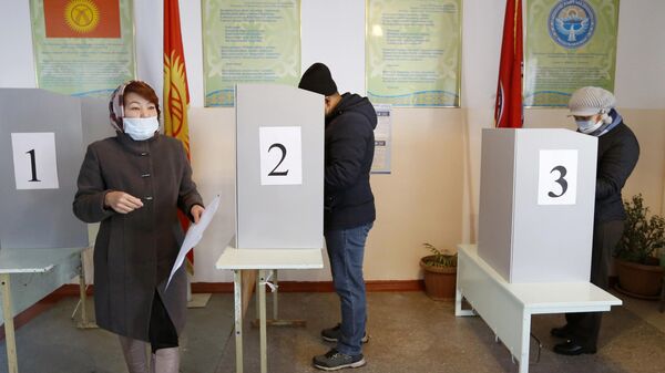 Люди голосуют на избирательном участке во время парламентских выборов в Кыргызстане