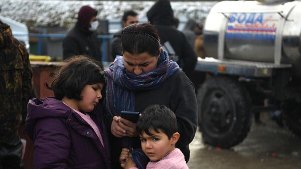 Женщина с детьми в центре временного содержания мигрантов, оборудованном в логистическом центре в пункте пропуска Брузги, на белорусско-польской границе
