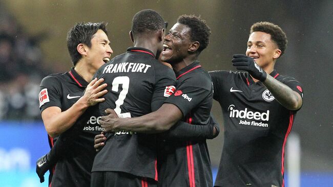 Frankfurt's French defender Evan N'Dicka (2L) celebrates with teammates after the German first division Bundesliga football match between Eintracht Frankfurt and 1 FC Union Berlin in Frankfurt, western Germany, on November 28, 2021.L (Photo by Daniel ROLAND / AFP) / DFL REGULATIONS PROHIBIT ANY USE OF PHOTOGRAPHS AS IMAGE SEQUENCES AND/OR QUASI-VIDEO