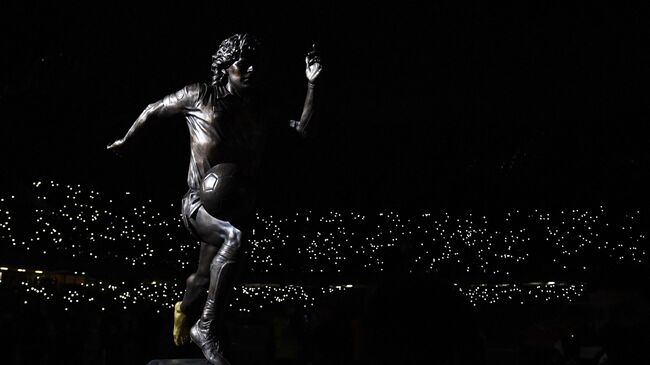 A bronze statue depicting  Argentinian football legend Diego Armando Maradona is displayed on the pitch ahead of the Italian Serie A football match between Naples (Napoli) and Lazio Rome at Diego-Armando-Maradona stadium in Naples, on November 28, 2021. - Naples is paying homage to Diego Maradona on the first anniversary of his death with three statues, two to be set up in the recently renamed Diego Armando Maradona football stadium and one already sitting in the city's National Archaeological Museum. (Photo by Alberto PIZZOLI / AFP)