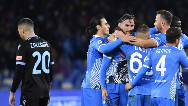 Napoli's Spanish midfielder Fabian Ruiz (C) is congratulated by teammates after scoring a goal during the Italian Serie A football match between Naples (Napoli) and Lazio Rome at Diego-Armando-Maradona stadium in Naples, on November 28, 2021. (Photo by Alberto PIZZOLI / AFP)