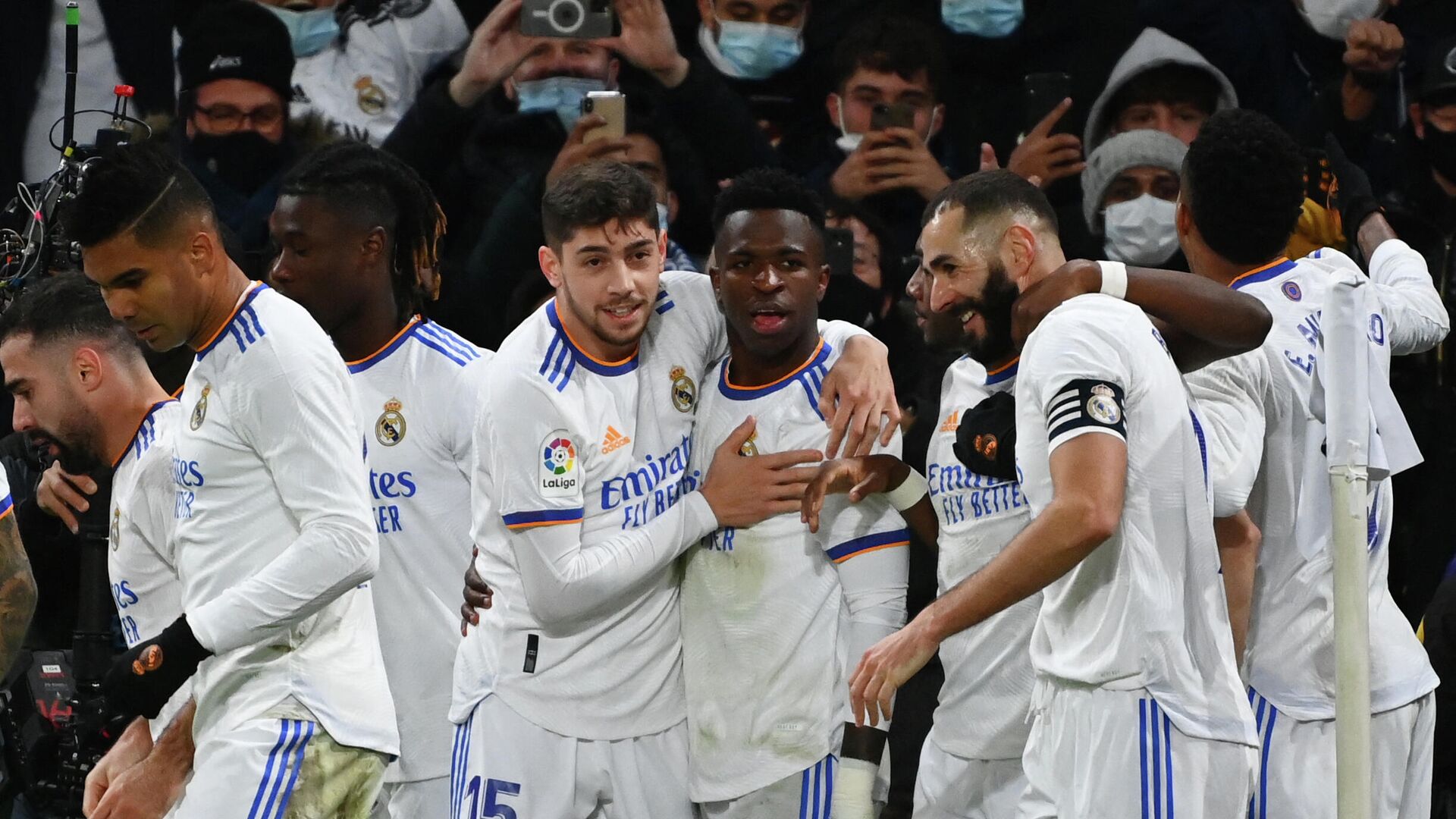 Real Madrid's Brazilian forward Vinicius Junior (C) is congratulated by teammates after scoring a goal during the Spanish league football match between Real Madrid CF and Sevilla FC at the Santiago Bernabeu stadium in Madrid on November 28, 2021. (Photo by GABRIEL BOUYS / AFP) - РИА Новости, 1920, 29.11.2021