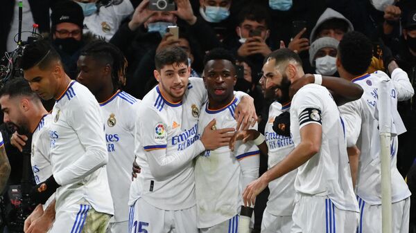 Real Madrid's Brazilian forward Vinicius Junior (C) is congratulated by teammates after scoring a goal during the Spanish league football match between Real Madrid CF and Sevilla FC at the Santiago Bernabeu stadium in Madrid on November 28, 2021. (Photo by GABRIEL BOUYS / AFP)