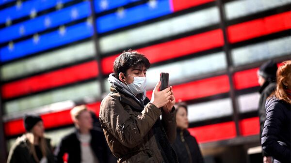 Мужчина со смартфоном на Таймс-сквер в Нью-Йорке, США