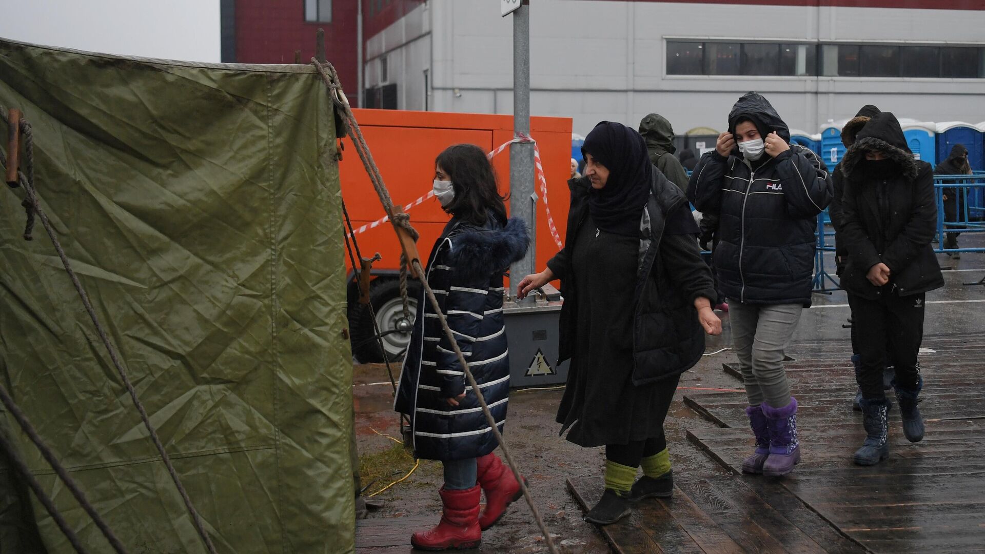 Беженцы в очереди за продуктами в центре временного содержания мигрантов, оборудованном в логистическом центре в пункте пропуска Брузги1