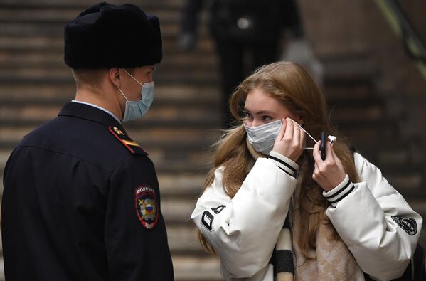 Сотрудник полиции и пассажир во время рейда по соблюдению масочного режима в метро на станции Красный проспект в Новосибирске