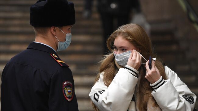 Сотрудник полиции и пассажир во время рейда по соблюдению масочного режима в метро на станции Красный проспект в Новосибирске