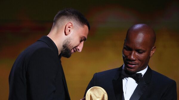 Paris Saint-Germain's Italian goalkeeper Gianluigi Donnarumma is   awarded the   Yashin Trophy for best goalkeeper by Ivorian former football player and evening host Didier Drogba during  the 2021 Ballon d'Or France Football award ceremony at the Theatre du Chatelet in Paris on November 29, 2021. (Photo by FRANCK FIFE / AFP)