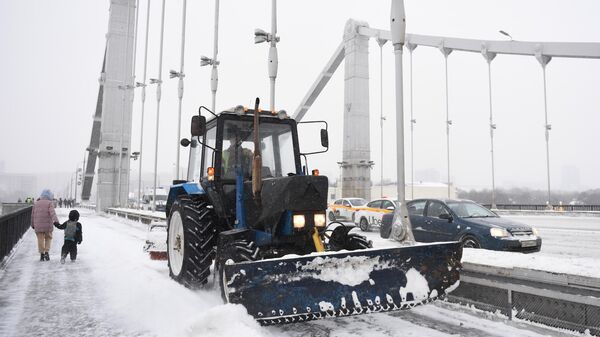 Снегоуборочная техника расчищает от снега и наледи Крымский мост во время снегопада в Москве