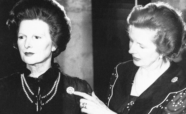 Премьер-министр Великобритании Маргарет Тэтчер рассматривает брошь на ее восковой фигуре в Музее восковых фигур мадам Тюссо в Лондоне