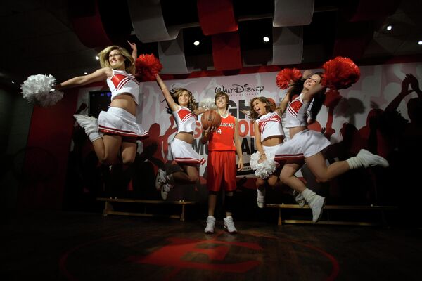 Восковая модель американского актера Зака Эфрона стоит в центре, пока чирлидерши из британской танцевальной труппы 'Storm' позируют фотографам в музее восковых фигур мадам Тюссо в Лондоне