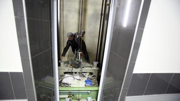 Рабочие ремонтируют лифт