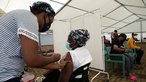 Женщина во время вакцинации против COVID-19 в ЮАР