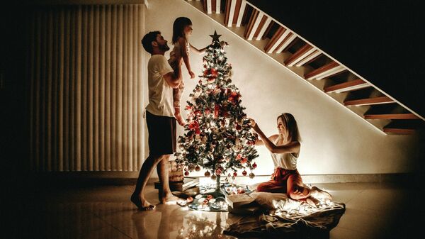 Семья наряжает новогоднюю елку