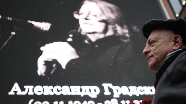Мужчина с цветами у здания театрально-концертного музыкального объединения Градский Холл в Москве во время церемонии прощания с народным артистом России