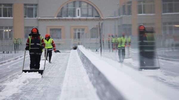 Уборка снега на Парящем мосту в парке Зарядье в Москве