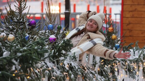 Девушка фотографируется у заснеженных елок на Красной площади в Москве