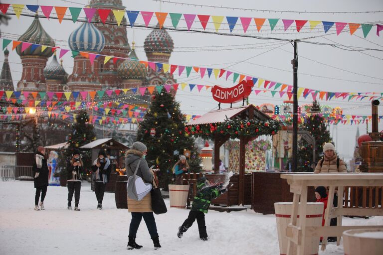 Посетители ярмарки на Красной площади в Москве после снегопада