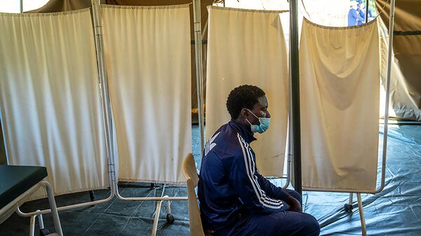 Мужчина в пункте вакцинации в клинике недалеко от Йоханнесбурга