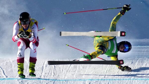 Тобиас Мюллер из Германии упал во время соревнований с Йоханнесом Ауески из Австрии во время финала во время Кубка мира FIS по ски-кроссу, Хэбэй, Китай