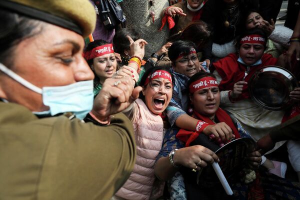 Офицер полиции пытается сдержать участников акции протеста против роста инфляции в стране, Нью-Дели, Индия