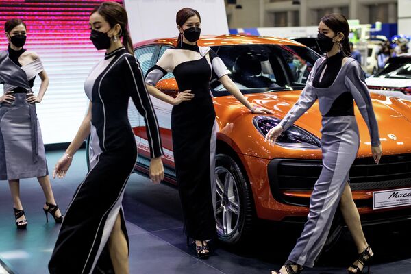 Модели возле автомобиля Porsche Macan на таиландской выставке Motor Expo