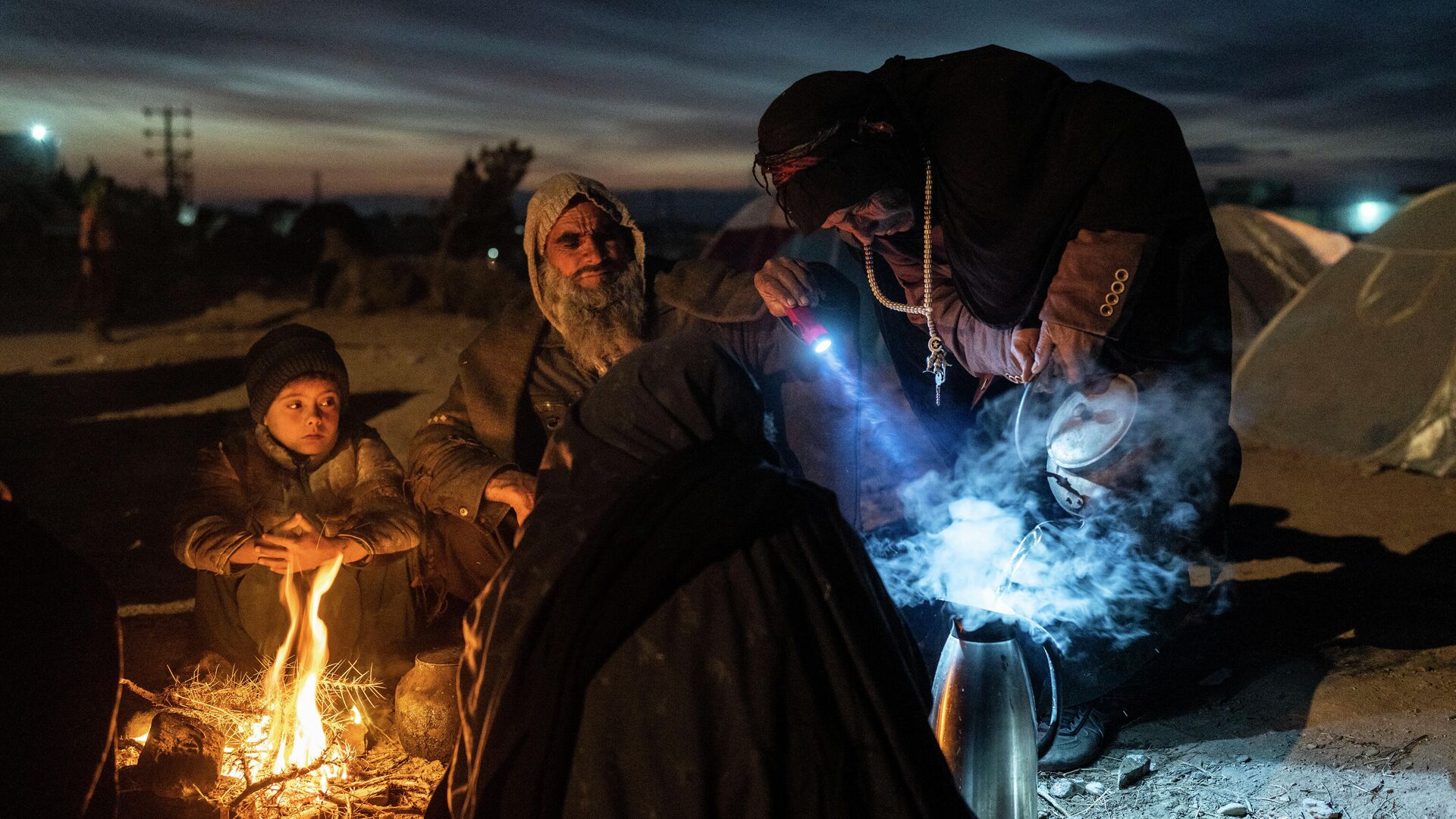 Семья беженцев готовит чай около Управления по чрезвычайным ситуациям Афганистана в Герате  - РИА Новости, 1920, 23.01.2022
