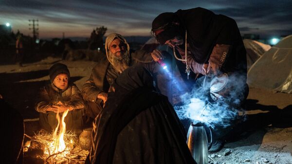 Семья беженцев готовит чай около Управления по чрезвычайным ситуациям Афганистана в Герате 