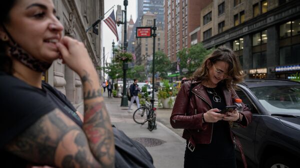 Женщина в Нью-Йорке проверяет свою учетную запись в соцсети