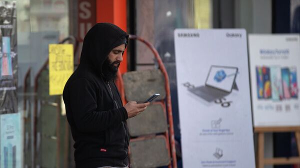 Житель Кашмира просматривает Интернет на своем мобильном телефоне