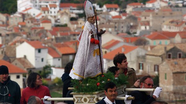 Жители несут статуэтку Святого Николая во время крестного хода, в городе Комижа, Хорватия