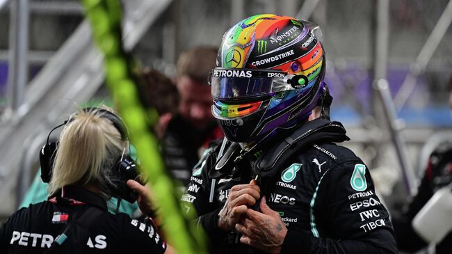 Mercedes' British driver Lewis Hamilton stands in the pits during a stop in the session during the Formula One Saudi Arabian Grand Prix at the Jeddah Corniche Circuit in Jeddah on December 5, 2021. (Photo by ANDREJ ISAKOVIC / various sources / AFP)