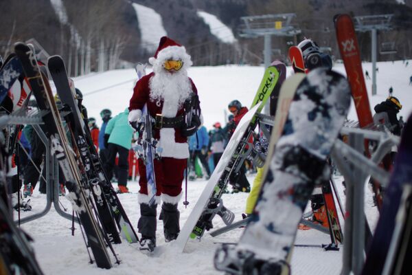 Лыжник на благотворительном заезде Санта-Клаусов на горнолыжном курорте Бетел в США