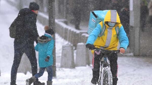 Люди во время снегопада в Петербурге