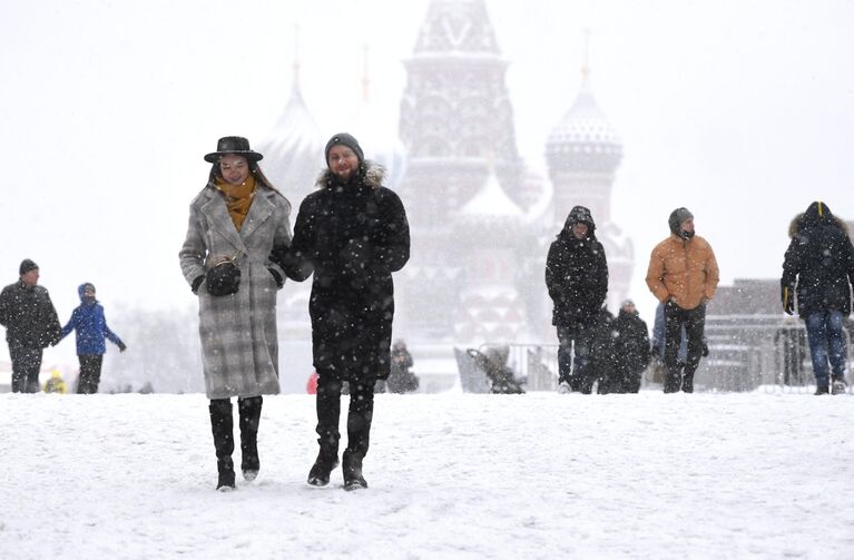 Люди на Красной площади в Москве во время снегопада