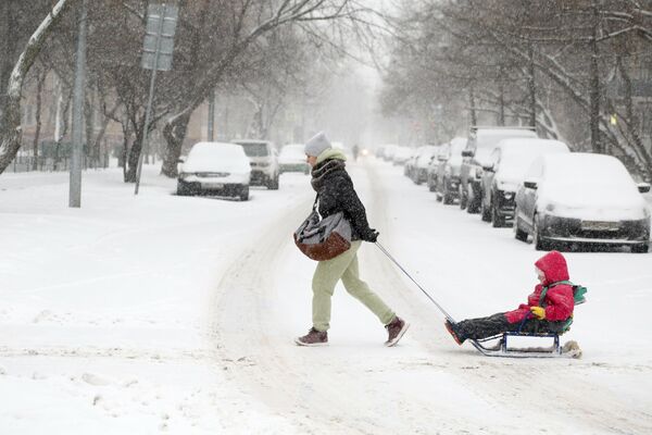 Девушка с ребенком во время снегопада в Москве