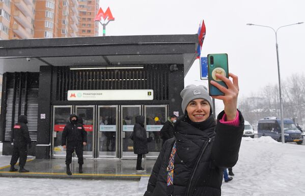 Девушка фотографируется на фоне входа станции Новаторская южного участка Большой кольцевой линии (БКЛ) Московского метрополитена.