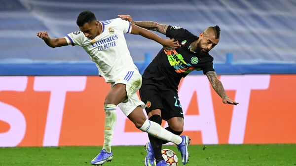 Real Madrid's Brazilian forward Rodrygo (L) fights for the ball with Inter Milan's Chilean midfielder Arturo Vidal during the UEFA Champions League first round group D football match between Real Madrid and Inter Milan at the Santiago Bernabeu stadium in Madrid on December 7, 2021. (Photo by PIERRE-PHILIPPE MARCOU / AFP)