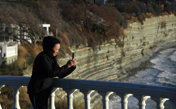 Женщина делает фото на набережной Геленджика
