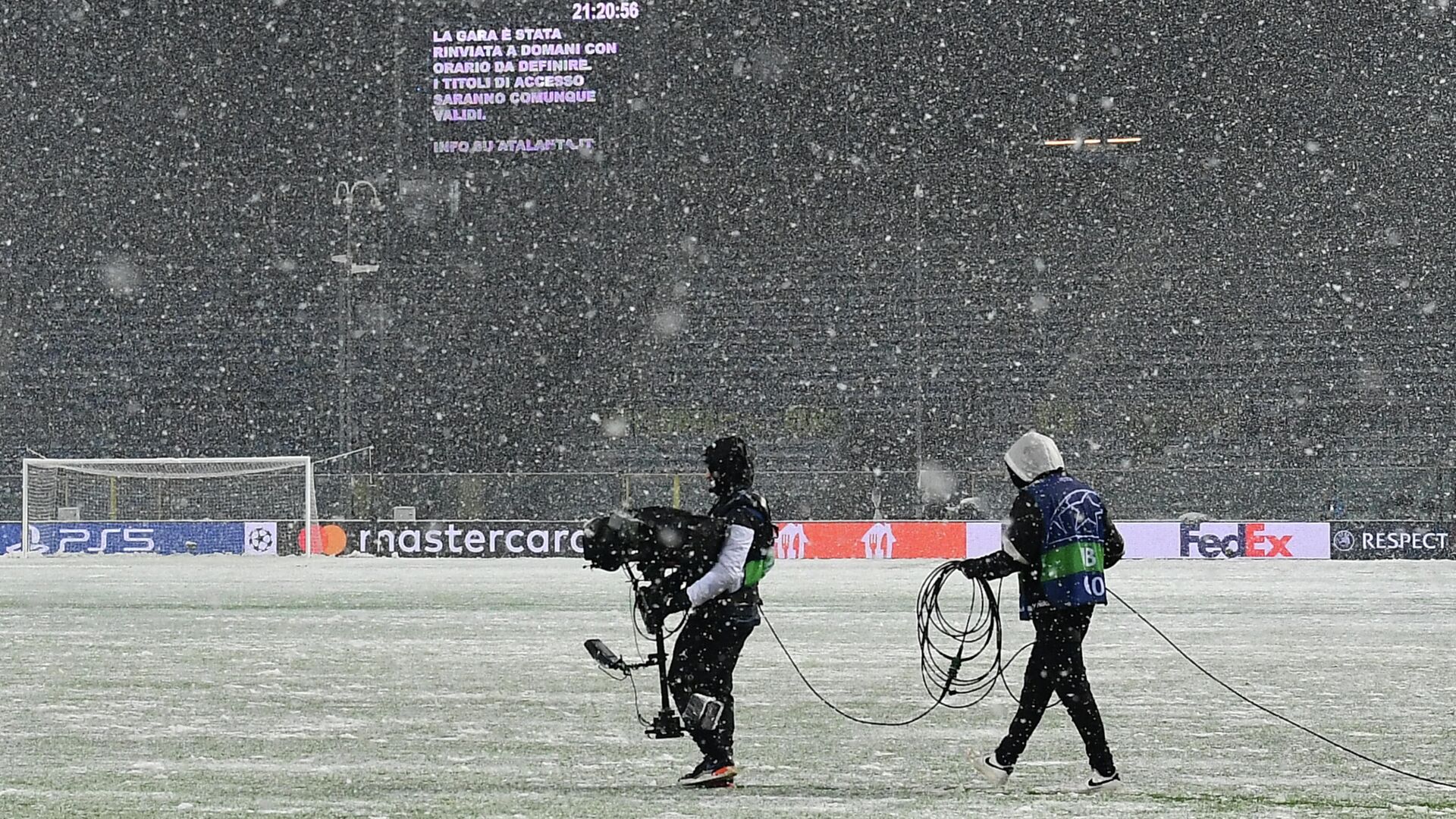 A screen displays the match has been postponed until tomorrow at a time to be determined after UEFA officials decided to postpone due to heavy snowfalls the Champions League Group F football match between Atalanta and Villarreal on December 8, 2021 at the Atleti Azzurri d'Italia stadium in Bergamo. (Photo by Isabella BONOTTO / AFP) - РИА Новости, 1920, 09.12.2021