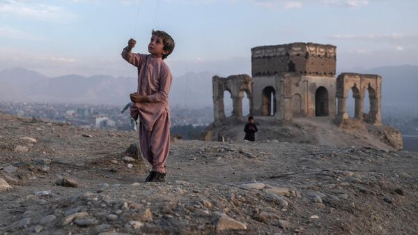 Мальчик запускает воздушного змея на холме Тейп Надир Хан в Кабуле, Афганистан