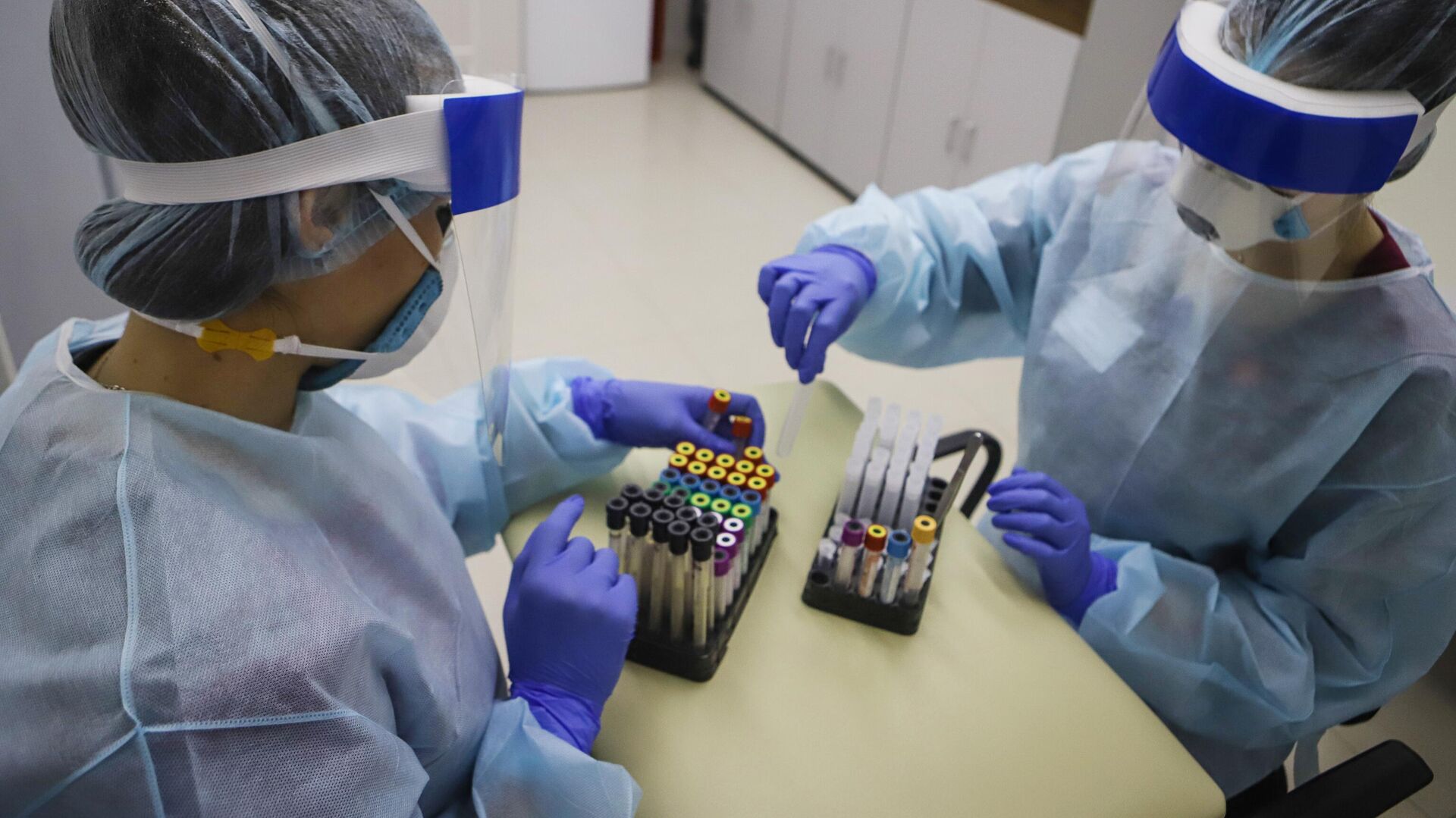 Медицинские работники обрабатывают полученный биоматериал на наличие антител к вирусу SARS-CoV-2  - РИА Новости, 1920, 28.12.2021