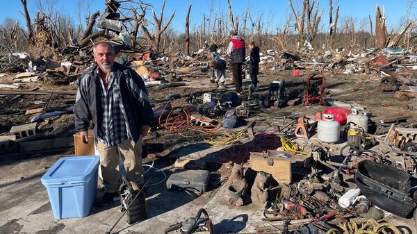 Местные жители на месте разрушенных в результате торнадо домов в городе Мэйфилд в штате Кентукки в США